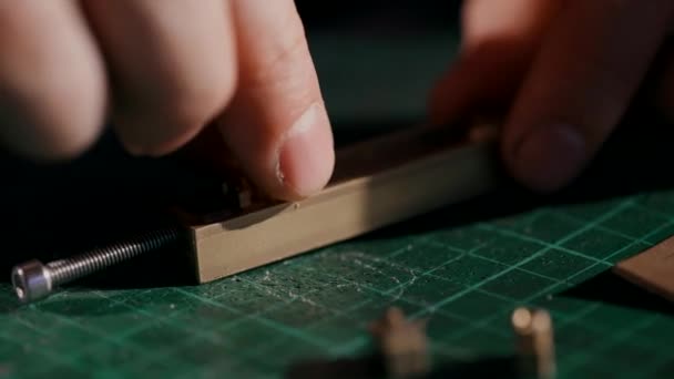 El proceso de fabricación de una cartera de cuero hecha a mano. El artesano estampó el logo. Vista lateral es macro. Artículos de cuero hechos a mano. — Vídeo de stock