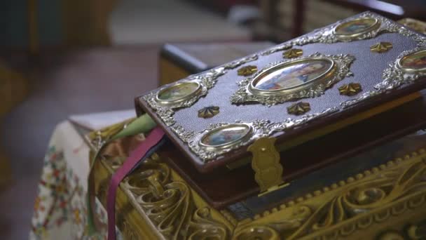 Uma mesa com uma cruz e um livro do Evangelho. No meio da Igreja Católica Ucraniana, localizada em Ivano-Frankivsk 2015. — Vídeo de Stock