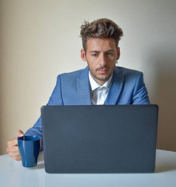 Çalışanlar evde dizüstü bilgisayarla çalışıyor, kahve içiyor.