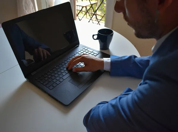 Man in suit teleworking from home because of coronavirus