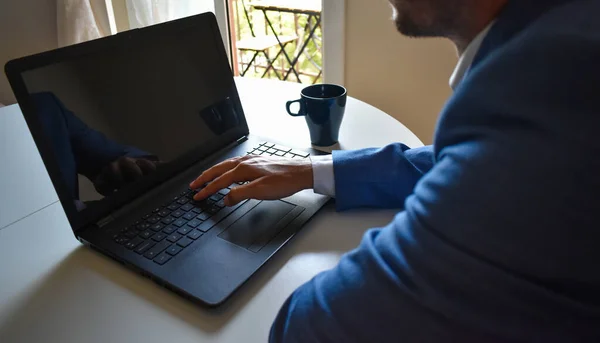 Man in suit teleworking from home because of coronavirus