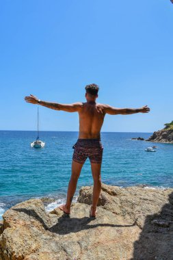 Yazın denize bakan arkadan genç bir adam