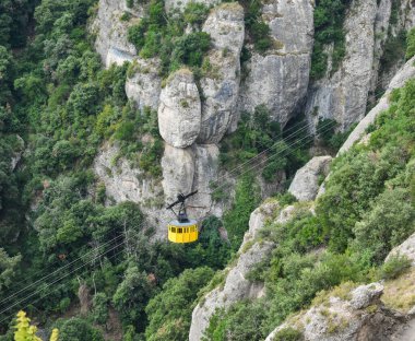 Sarı teleferik yüksek irtifada dağları geçiyor.