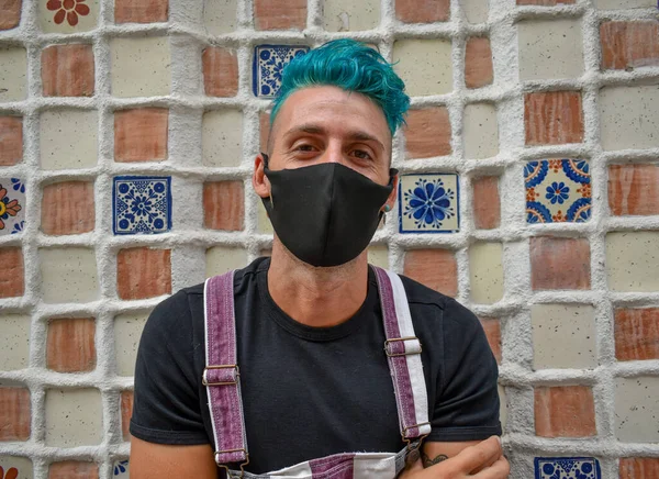 Young man with blue hair wearing a face mask during the coronavirus pandemic