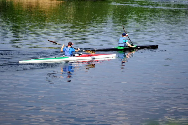 two girls rowing boats on the lake