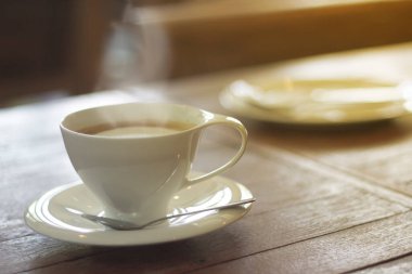 Sabahları, bir kahve dükkanındaki ahşap bir masanın üzerinde bir fincan espresso.