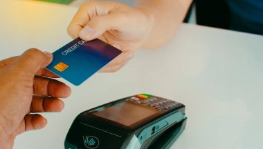 Tezgahta para ödeyen adam kredi kartları, alışveriş ve perakende fikirleri kullanarak ona para ödüyor..