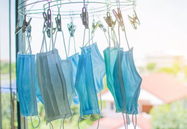 Havada asılı duran tıbbi maskeler, yeniden kullanım için güneşten sterilize edilmiş antivirüs maskeleri ve yetersiz kullanım nedeniyle virüsün yayılmasını engellemek..