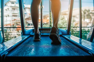 Sabahları koşu bandında egzersiz yapan bir adam yavaşça yürüyor..