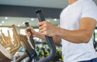 Erkekler sabahları spor salonunda kol ve bacak egzersiz makineleri kullanır..