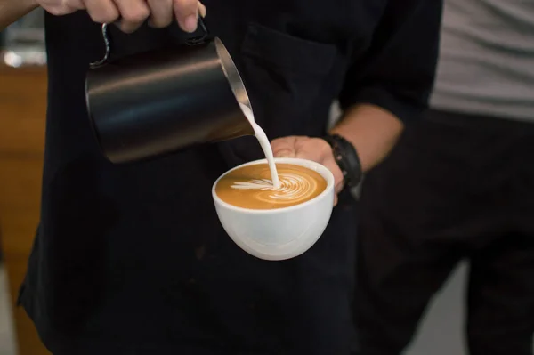 Kahveyi kahve dükkanında bir fincan Latte Art kahvesine dök..