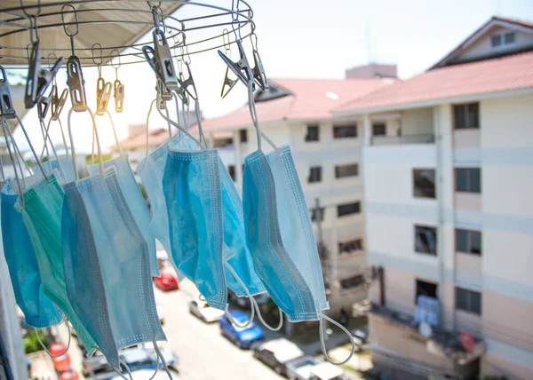 Medical masks hanging on clothes-drying equipment, sterilized by the sun for reuse, masks for protection against viruses and preventing the spread of viruses, due to insufficient masks
