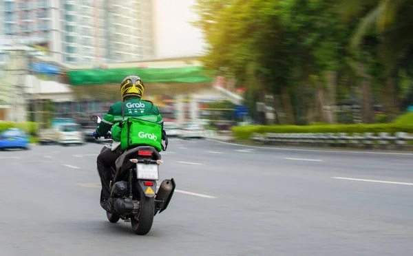 Motosiklet sürücüsü acilen Bangkok, Tayland, 28-04-2020 'de online sipariş veren müşterilere yiyecek getiriyor..