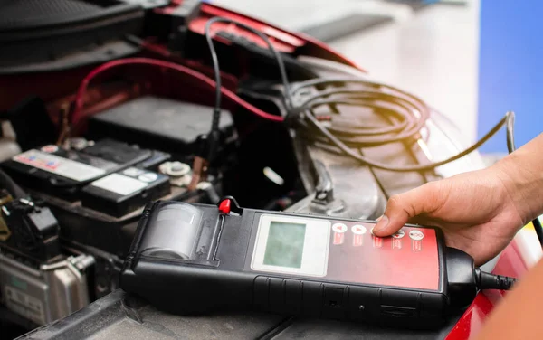 Der Mechaniker Überprüft Mit Dem Gerät Die Spannung Der Autobatterien — Stockfoto