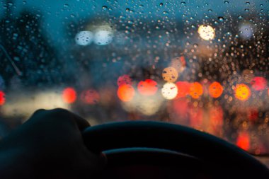 Araba sürerken arka plan, stop lambaları, bokeh ve yağmur damlaları bulanıklaşır.