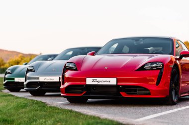 Alesund / Norveç - 31 Mayıs 2020: Park yerinde tanıtım amaçlı park edilmiş üç lüks Porsche Taycan sedan. Ön taraftan vurulmuş..