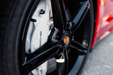 Alesund / Norveç - 31 Mayıs 2020: Kırmızı Porsche Taycan Sedan, tanıtım amaçlı park edilmiş. Tekerlek yakın çekim.