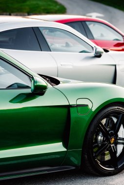Alesund / Norveç - 31 Mayıs 2020: Park yerinde tanıtım amaçlı park edilmiş üç lüks Porsche Taycan sedan. Dikey yan çekim