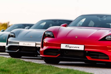 Alesund / Norveç - 31 Mayıs 2020: Park yerinde tanıtım amaçlı park edilmiş üç lüks Porsche Taycan sedan. Ön yakın çekim.. 