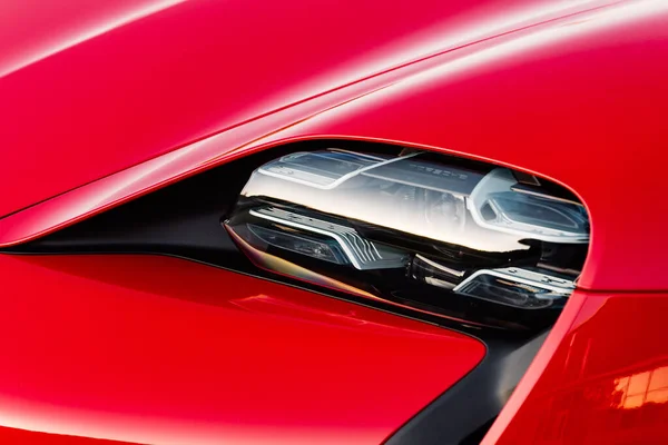 Alesund / Norveç - 31 Mayıs 2020: Kırmızı Porsche Taycan, tanıtım amaçlı park edilmiş bir otoparkta. Ön far çekimi. 