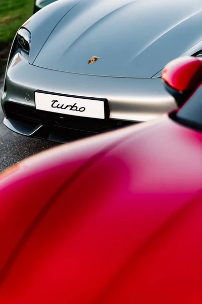 Alesund / Norveç - 31 Mayıs 2020: Park yerinde tanıtım amaçlı park edilmiş üç lüks Porsche Taycan sedan. Dikey kaput görüntüsü.