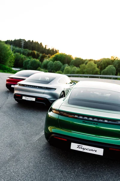 Alesund / Norveç - 31 Mayıs 2020: Park yerinde tanıtım amaçlı park edilmiş üç lüks Porsche Taycan sedan. Arkadan vurulmuş..