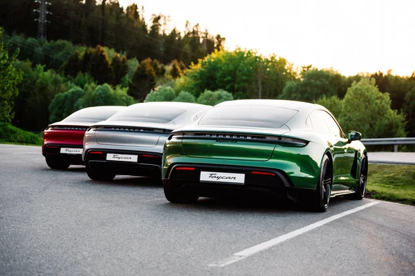 Alesund / Norveç - 31 Mayıs 2020: Park yerinde tanıtım amaçlı park edilmiş üç lüks Porsche Taycan sedan. Arka çekim.. 