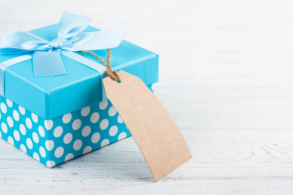 Blue gift box with ribbon on white wooden background. Father\'s day concept with copy space