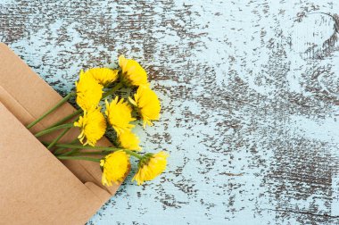 Zanaat zarf işareti sevgi ve sarı kasımpatı çiçekleri ile. Üstten görünüm. Açık mavi renkli düz yatıyordu