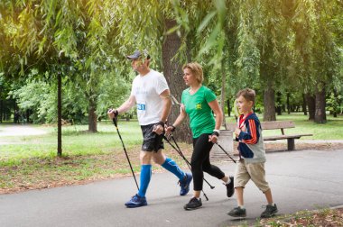 Kiev, Ukrayna - 24 Haziran 2018: Aile maraton katılan Park nordic Walkers. Baba, Anne, oğlu bitirmek doğru yürüyüş