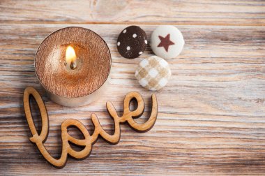 Ahşap işareti aşk, düğmeleri ve ahşap arka plan üzerinde yanan mum ile tebrik kartı