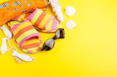 Çizgili terlik, kabukları, güneş gözlüğü ve sarı zemin üzerine çakıl. Metniniz için kopya alanı