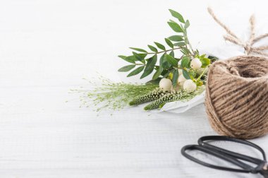 Buket çiçekler, yapraklar, çırpı, Beyaz ahşap arka plan üzerinde sicim. Konsept atölye ya da kutlama için. Eski püskü şık stili