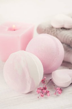 Pembe banyo bombalar ile Spa kompozisyon kalp Beyaz ahşap zemin üzerinde. Üstten görünüm, kopya alanı 