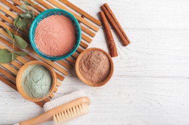 Kırmızı ve mavi kozmetik Fas kil tozu, beyaz arka plan üzerinde yanan mum ile spa kompozisyon