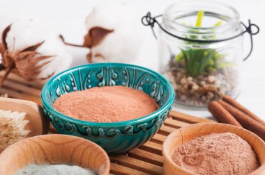 Kırmızı ve mavi kozmetik Fas kil tozu, beyaz arka plan üzerinde yanan mum ile spa kompozisyon