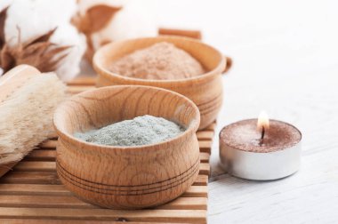 Kırmızı ve mavi kozmetik Fas kil tozu, beyaz arka plan üzerinde yanan mum ile spa kompozisyon