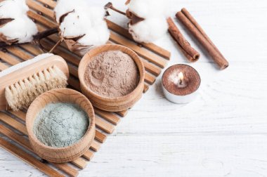 Kırmızı ve mavi kozmetik Fas kil tozu, beyaz arka plan üzerinde yanan mum ile spa kompozisyon