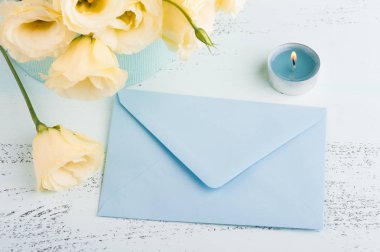 Sarı eustoma çiçek ve mavi masada zarf. Doğum günü, kadın ya da anneler günü için tebrik kartı