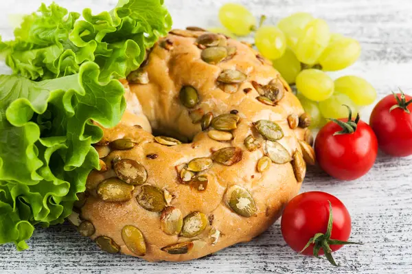 Bagel Ensalada Tomate Primer Plano Uva Mesa Madera —  Fotos de Stock