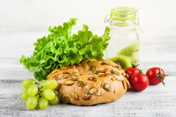 Bagel Ensalada Tomate Primer Plano Uva Mesa Madera —  Fotos de Stock