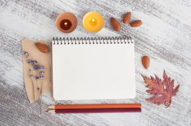 Boş defter ve kalemler, yanan mumlar ve Sonbahar dekorasyonu ahşap tablo