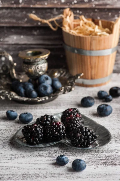 Berries on tin plate on wooden table