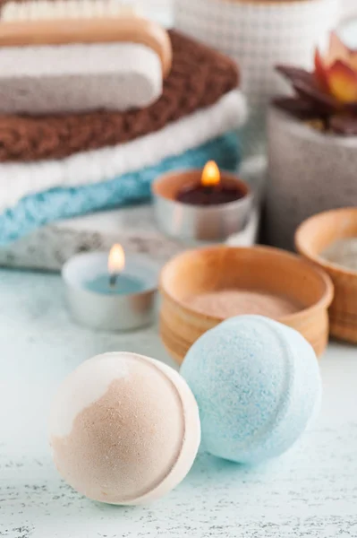 Bath bombs and moroccan clay powder, spa composition with brush and lit candles on white background