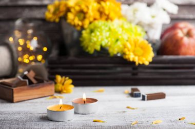 Yanan mumlar, krizantem ve ahşap arka plan üzerinde yanan ışıklar