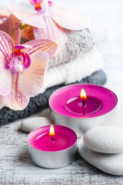 Spa natürmort çakıl ve mor turuncu orkide, ahşap arka plan üzerinde mum yaktı