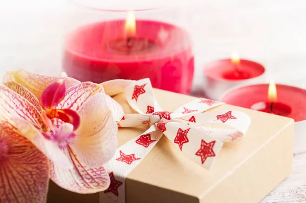 Orchideeën Ambachtelijke Cadeau Doos Aangestoken Kaarsen Kaarsen Een Blauwe Achtergrond — Stockfoto
