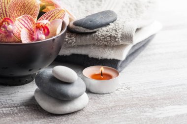 Spa natürmort çakıl ve kırmızı turuncu orkide, ahşap arka plan üzerinde mum yaktı