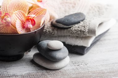 Spa natürmort çakıl ve kırmızı turuncu orkide, ahşap arka plan üzerinde mum yaktı