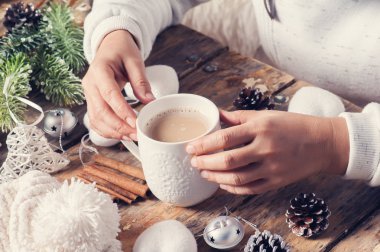 Kahve, Noel dekor içki masasında oturan kız. Koyu ahşap arka plan ellerde closeup